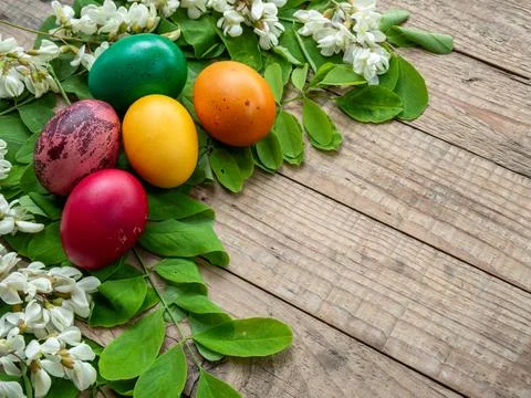 Easter eggs on rustic wooden table with greenery and white blossoms Foto stock
