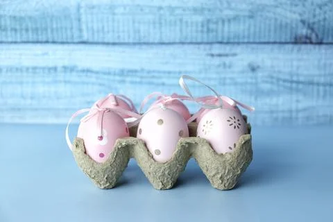 Easter eggs with silk ribbons on a blue monochromatic background Stock Photos