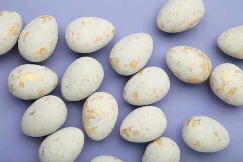 Easter eggs in a speck on purple background. Easter holiday composition Stock Photos