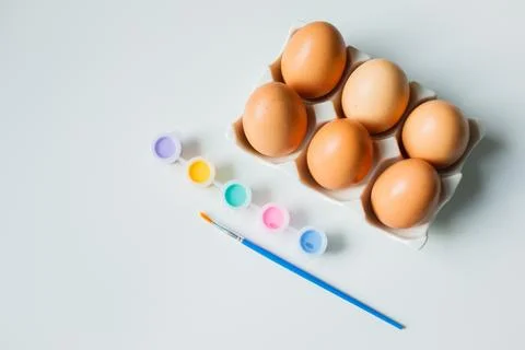 Easter eggs on a stand with paints and brush on white background. Christian.. Stock-Fotos