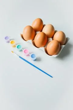 Easter eggs on a stand with paints and brush on white background. Eggs deco.. Stock Photos