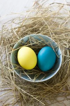Easter eggs in straw plate on a white background 스톡 사진
