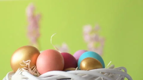 Easter eggs in straw spin on green background Video stock 148287673