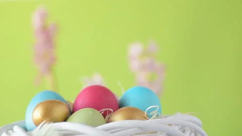 Easter eggs in straw spin on green background Stock Footage 148287689