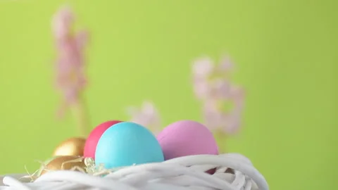 Easter eggs in straw spin on green background Video stock 148287695