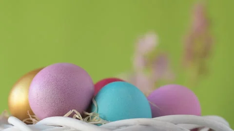 Easter eggs in straw spin on green background Video stock 148287786