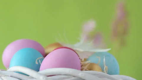 Easter eggs in straw spin on green background. Video stock 148287832