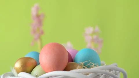 Easter eggs in straw spin on green background Stock Footage 148289538