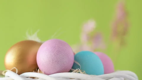 Easter eggs in straw spin on green background Stock Footage 148290921