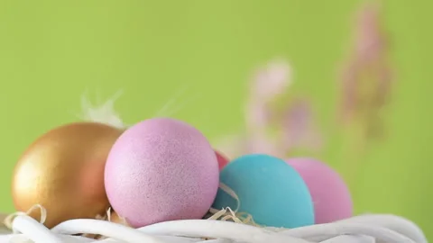 Easter eggs in straw spin on green background Stock Footage 148291012