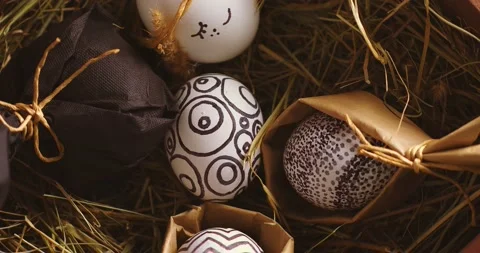 Easter eggs with stylish monochrome patterns lying on hay rotating, close up top Stock Footage 150954022