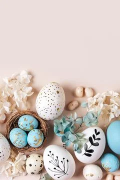 Easter eggs with sweets and flowers on beige. Happy Easter concept. White a.. Stock Photos