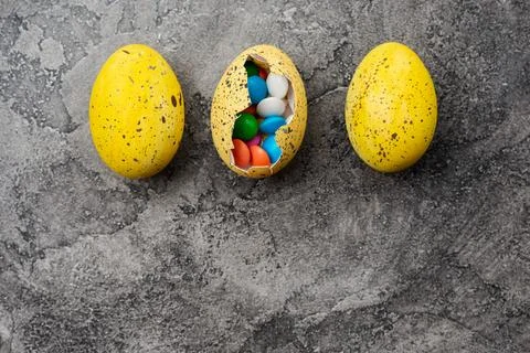 Easter eggs with sweets over gray background Stock Photos
