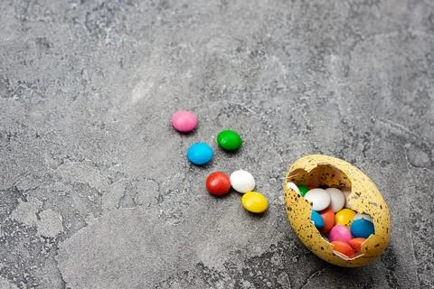 Easter Eggs with sweets over gray background Stock Photos