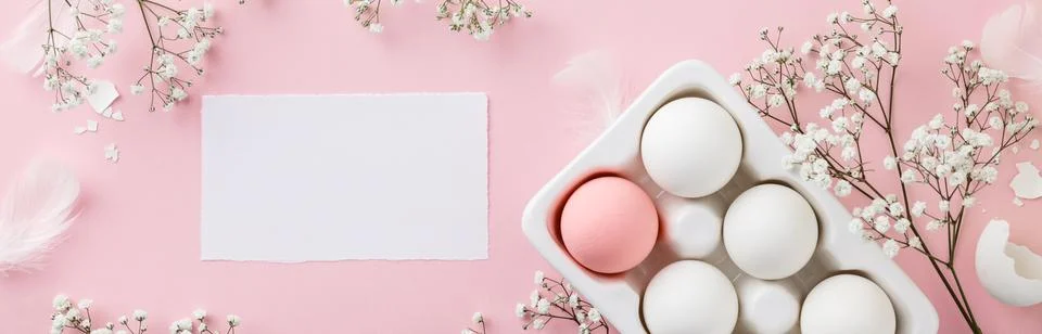 Easter eggs in white ceramic holder and flowers on pink background Stock Photos