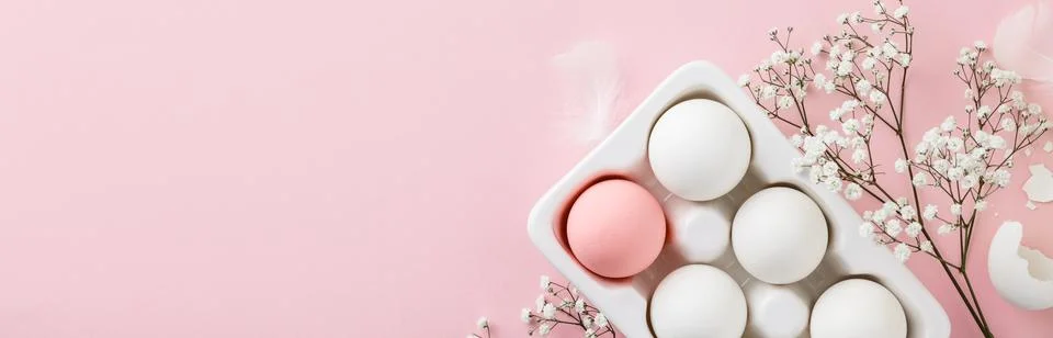 Easter eggs in white ceramic holder and flowers on pink background Stock Photos