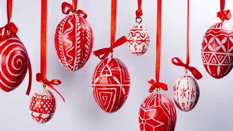 Easter eggs with white on red folk pattern, hang on red ribbons on white. Stock Footage 127888059