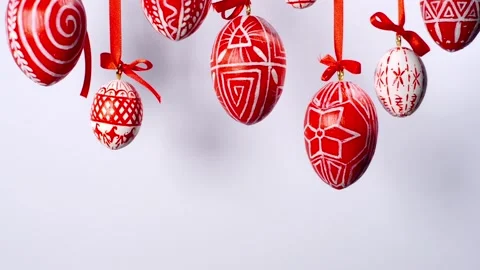 Easter eggs with white on red folk pattern, hang on red ribbons on white. Stock-Footage 127888270