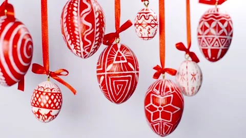 Easter eggs with white on red folk pattern, hang on red ribbons on white. Stock-Footage 127888292