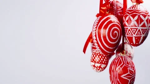 Easter eggs with white on red folk pattern, hang on red ribbons in right side Video stock 127888307