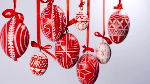 Easter eggs with white on red folk pattern, hang on red ribbons on white. Video stock 127888317