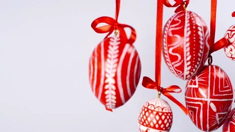 Easter eggs with white on red folk pattern, hang on red ribbons in right side Stock Footage 127888335