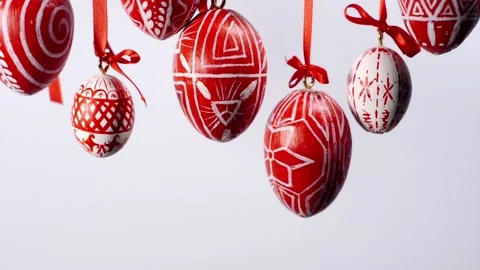 Easter eggs with white on red folk pattern, hang on red ribbons on white Video stock 127888368