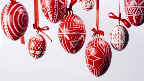 Easter eggs with white on red folk pattern, hang on red ribbons on white Video stock 127888387