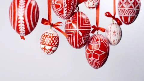 Easter eggs with white on red folk pattern, hang on red ribbons on white. Video stock 127888402