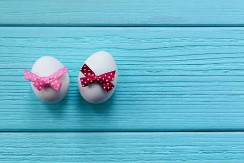 Easter eggs with white spotted bow on the red and pink colored wooden background Stock Photos