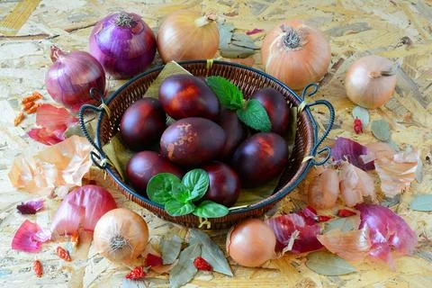 Easter eggs in wicker basket and onion Fotos de archivo