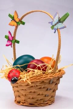 Easter eggs in wicker basket on white Stock Photos