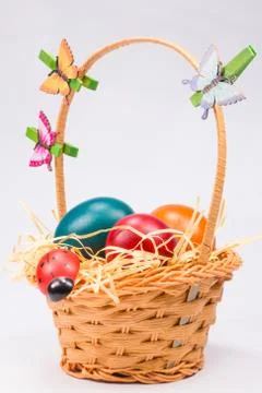 Easter eggs in wicker basket on white Stock Photos