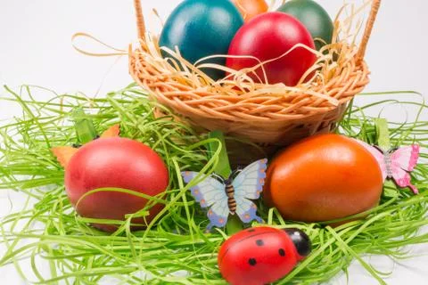 Easter eggs in wicker basket on white Stock Photos