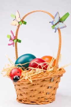 Easter eggs in wicker basket on white Stock Photos