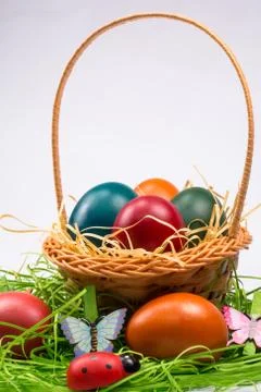 Easter eggs in wicker basket on white Stock Photos