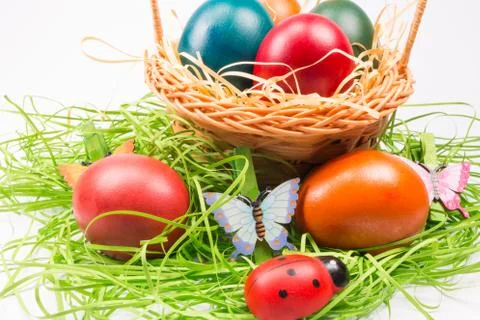 Easter eggs in wicker basket on white Stock Photos