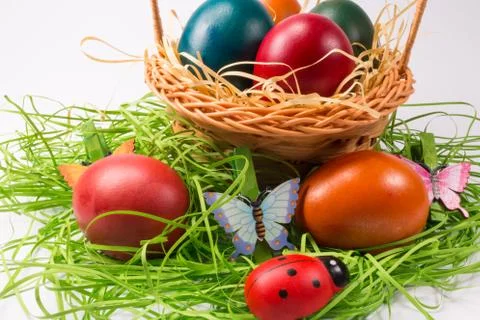 Easter eggs in wicker basket on white Stock Photos