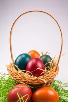 Easter eggs in wicker basket on white Stock Photos
