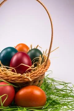 Easter eggs in wicker basket on white Stock Photos