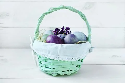 Easter eggs in a wicker basket on a white background. Easter composition Stock Photos
