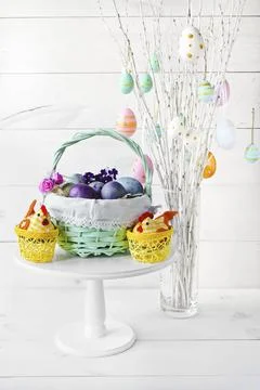 Easter eggs in a wicker basket on a white background Stock Photos
