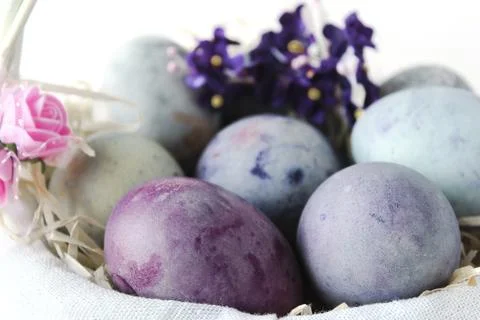 Easter eggs in a wicker basket on a white background Stock Photos