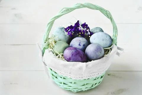 Easter eggs in a wicker basket on a white background Stock Photos