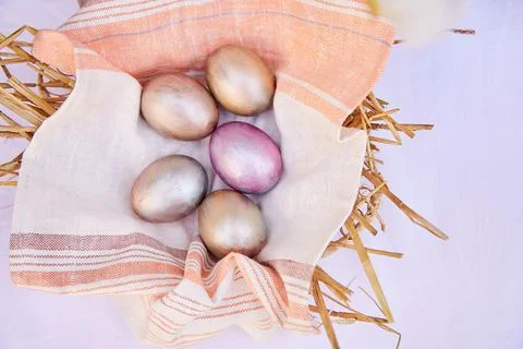 Easter eggs in wicker straw basket. Veri peri and orange multicolored eggs. View Stock Photos