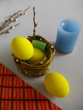 Easter eggs with willow branches and a candle. Stock Photos