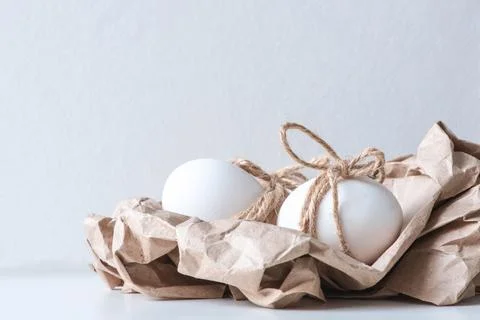 Easter eggs wrapped in eco-friendly kraft paper and decorated with twine on a Stock Photos