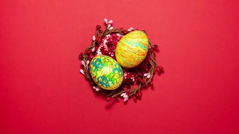 Easter eggs in a wreath of twigs on red stars Stock Footage 123808708