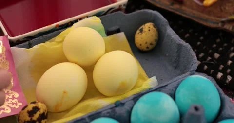 Easter eggs in yellow and blue colors in this fun egg painting process with Stock Footage 306067093