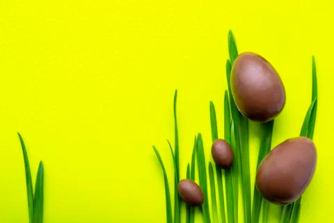 Easter eggs on a yellow background. Two large and two small chocolate eggs on Stock Photos